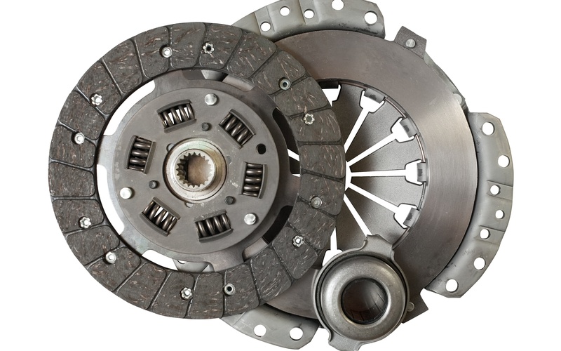 Component of a new automotive clutch kit, including a new clutch disc, isolated against a white background.