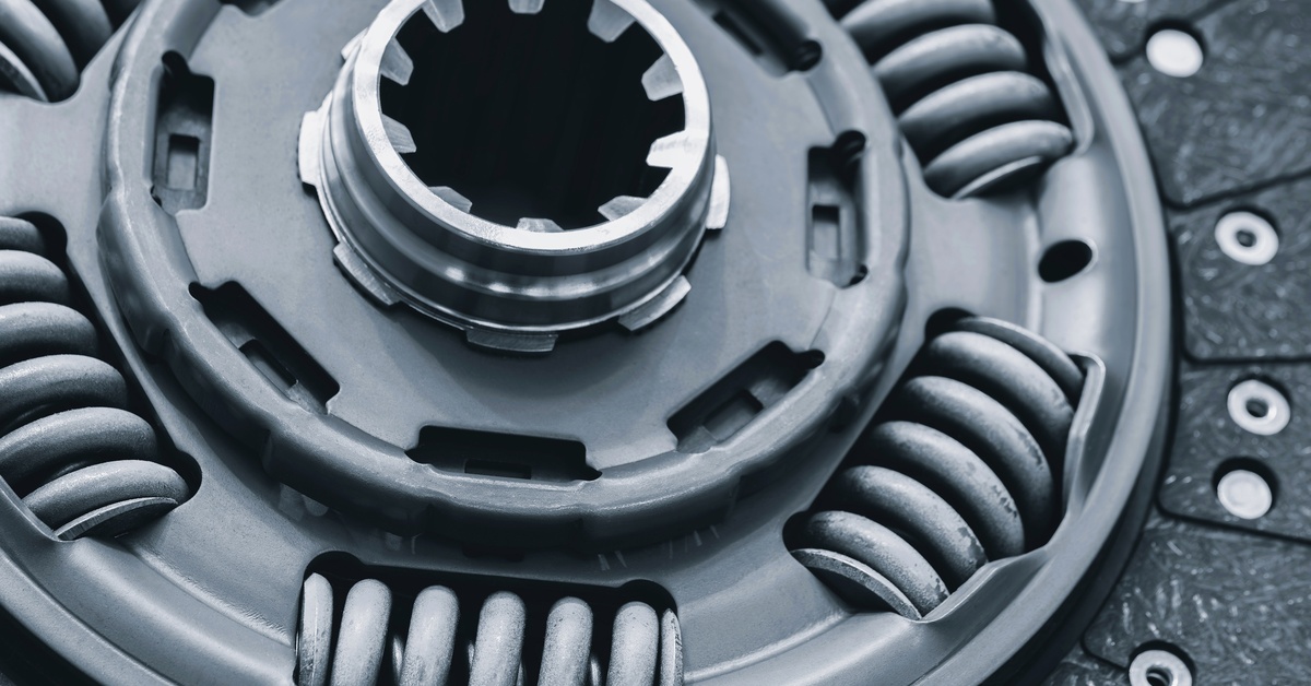 A close-up of a brand-new automotive high-carbon steel clutch disc, including its hub with splines and damper springs.