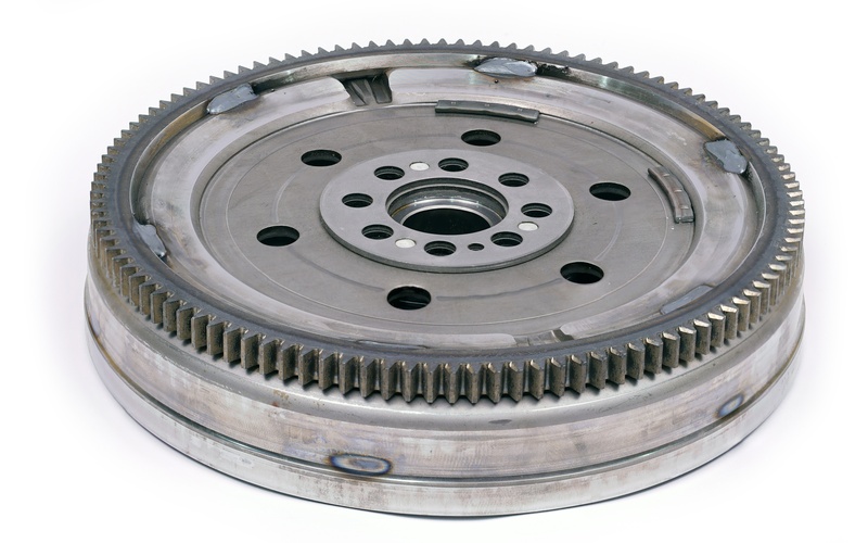 A close-up of a flywheel dampener for an automotive diesel engine isolated against a white background.