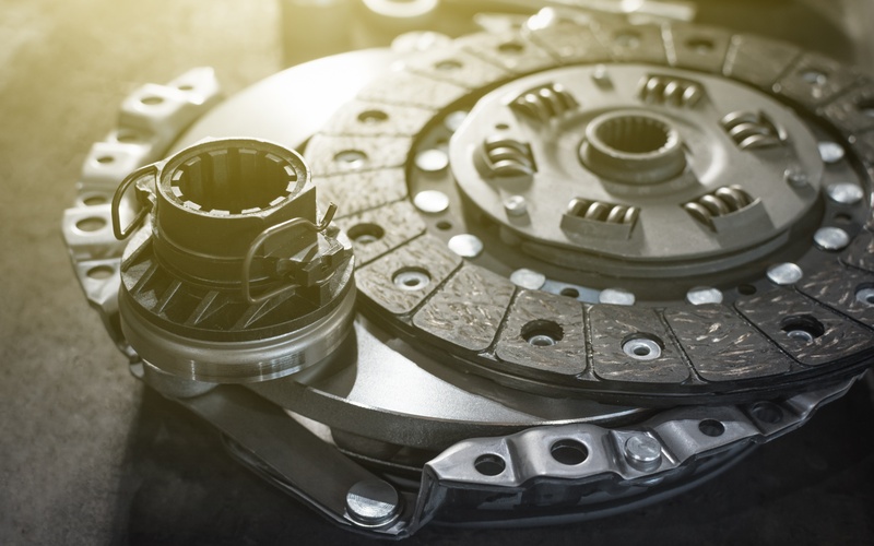 A close-up of a new automotive performance clutch kit, including clutch disc, flywheel, and release bearing.