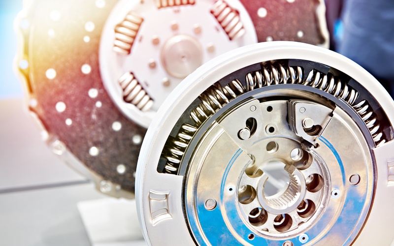 A close-up of a dual mass flywheel outside of a vehicle on display, including stainless steel clutch discs.