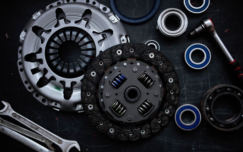 An overhead view of the components of a new clutch kit, including the flywheel bearing and clutch disc.