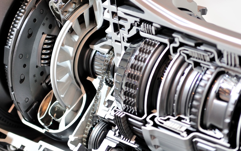 A close-up of the gearbox and clutch of a car in cross-section to show the inner components and mechanics.