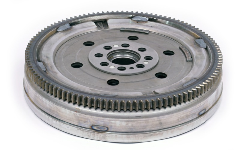 A close-up of an automotive flywheel with a dampener for a diesel engine against a blank white background.