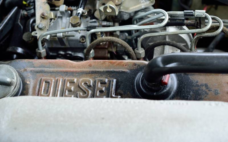 The engine compartment and inner workings of a diesel engine with the text "DIESEL" printed on a metal piece.