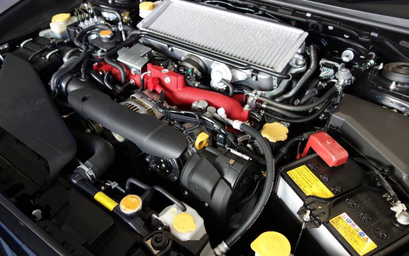 The open engine compartment of a Subaru sport sedan that shows the intercooler turbo box engine at rest.