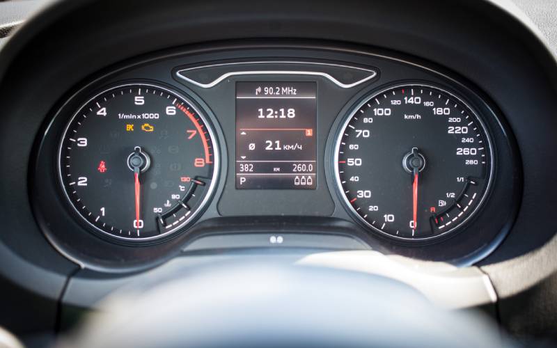 A close-up of the driver dashboard speedometer and RPM gauge of an Audi car with a center digital display.