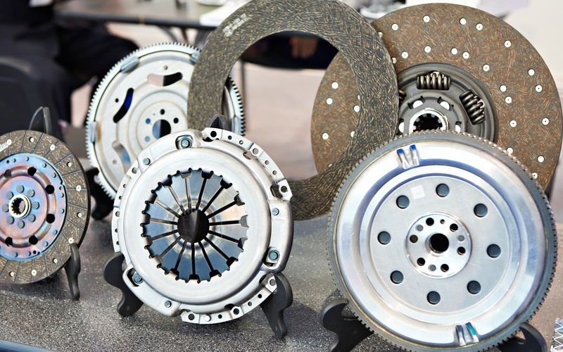 A display of manual transmission clutch parts, including multiple discs and pressure plates, on a counter.