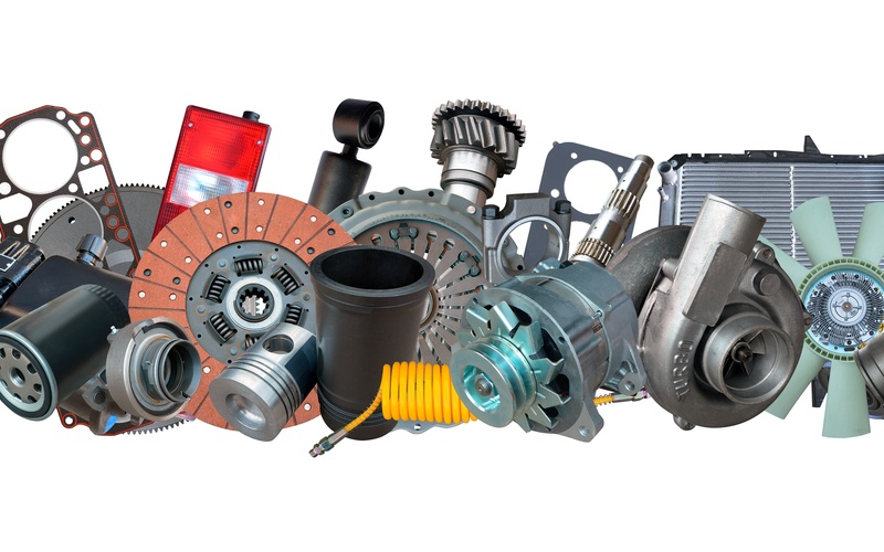 Various automotive parts, including filters, clutch discs, and turbochargers, are propped up against a white background.