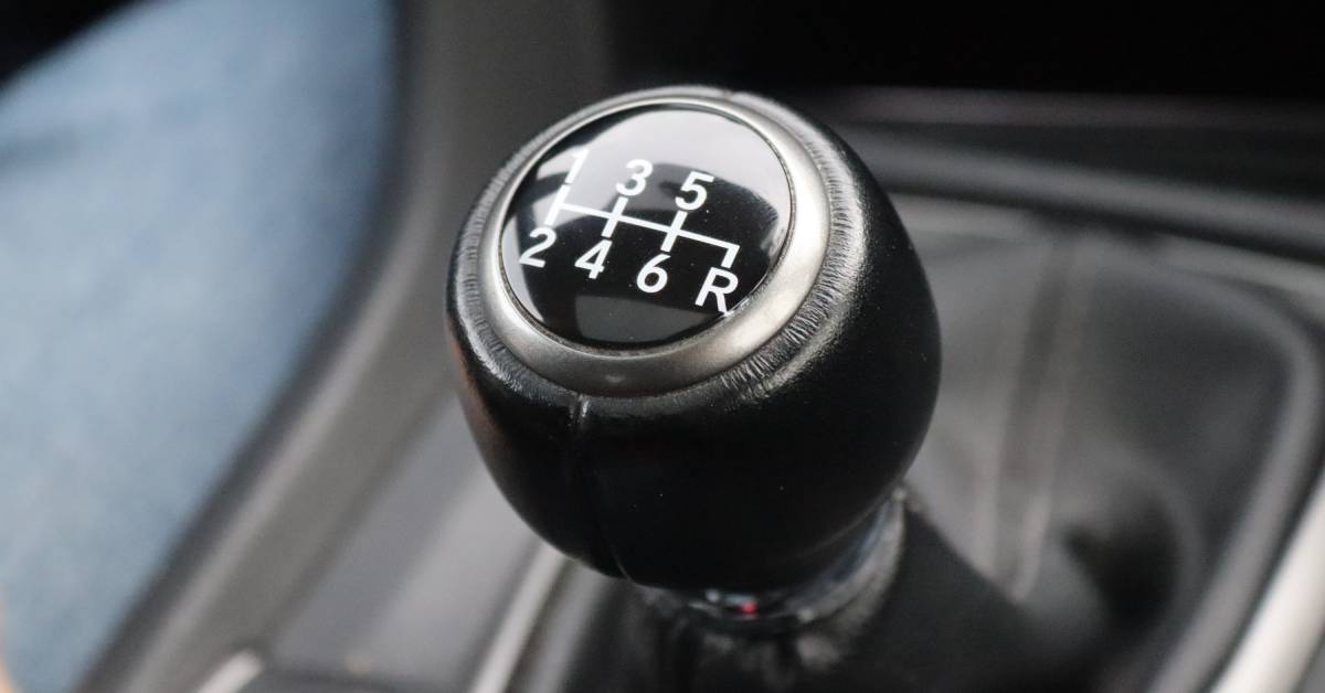 The gear stick of a manual Honda Civic showing the six gears and reverse in white lettering against a black background.