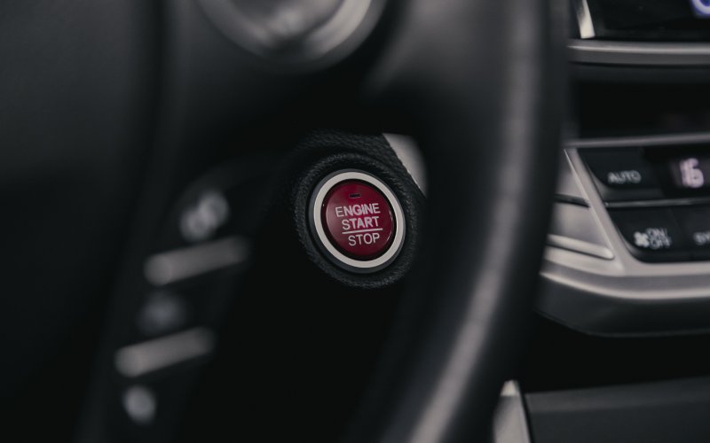 A close-up of the ignition start button of a Honda Accord. The button is red with the text, "ENGINE START | STOP."