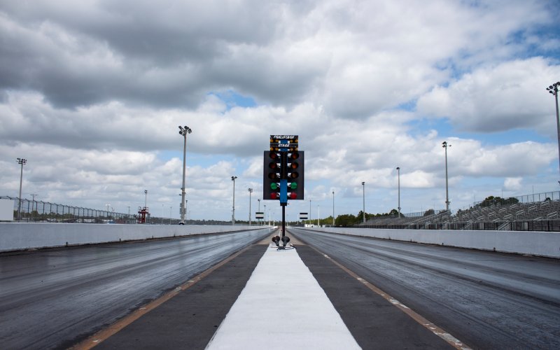 A view from the starting line of a drag racing track with parallel drag strips and a drag racing tree.