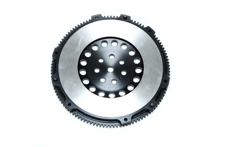 A brand-new, shiny, lightweight automotive engine flywheel isolated against a blank-white background.